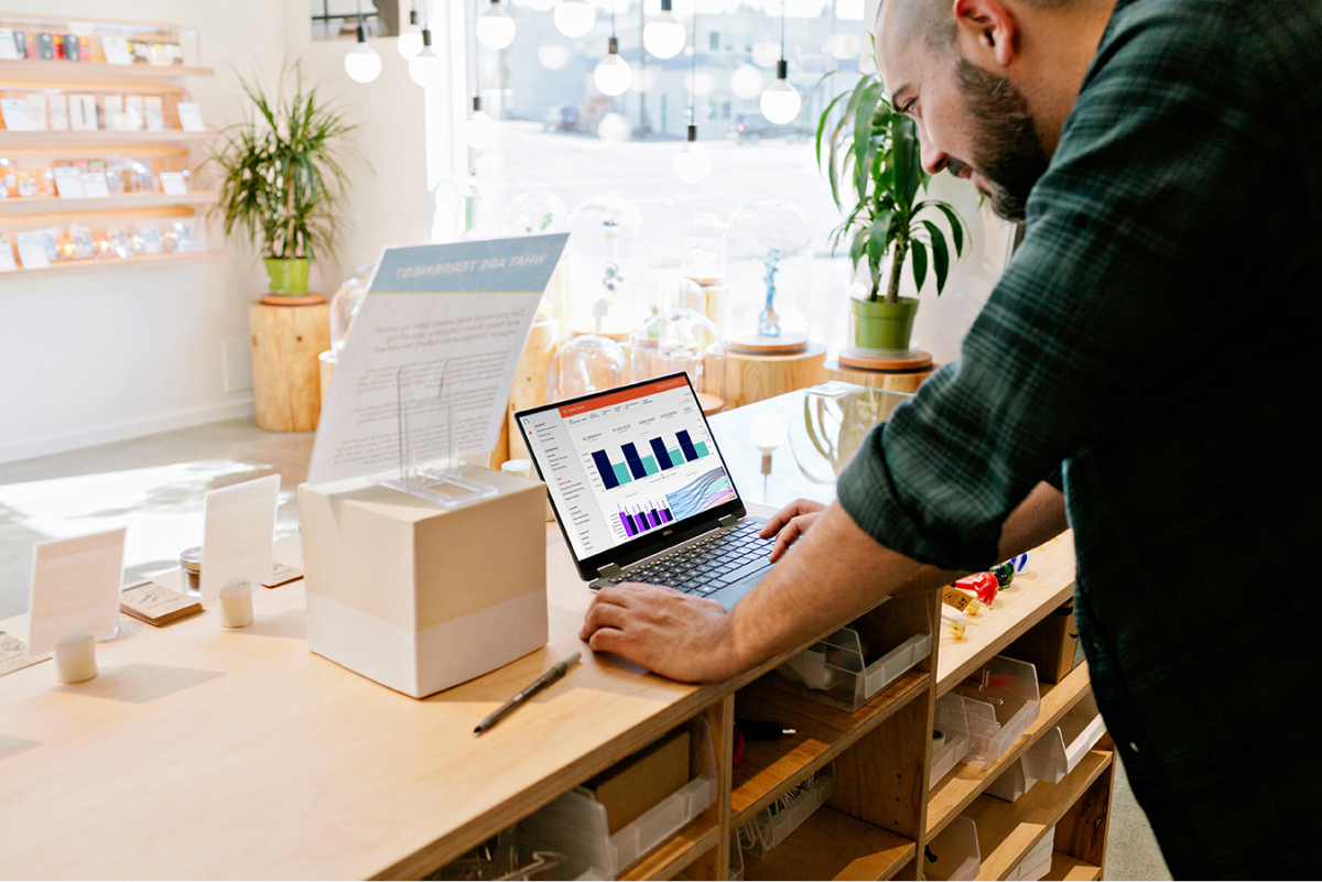 Retailer reviewing data on a laptop in a dispensary