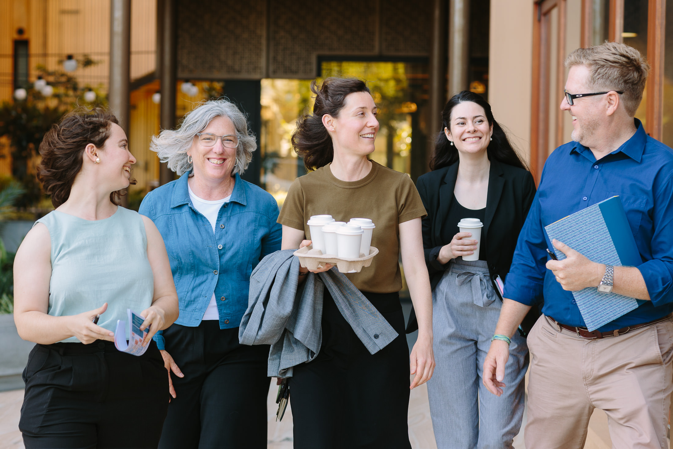 Happy team of work colleagues walking and talking outside coffee shop in Adelaide. Dave Pascoe commercial photographer - Palms Photography