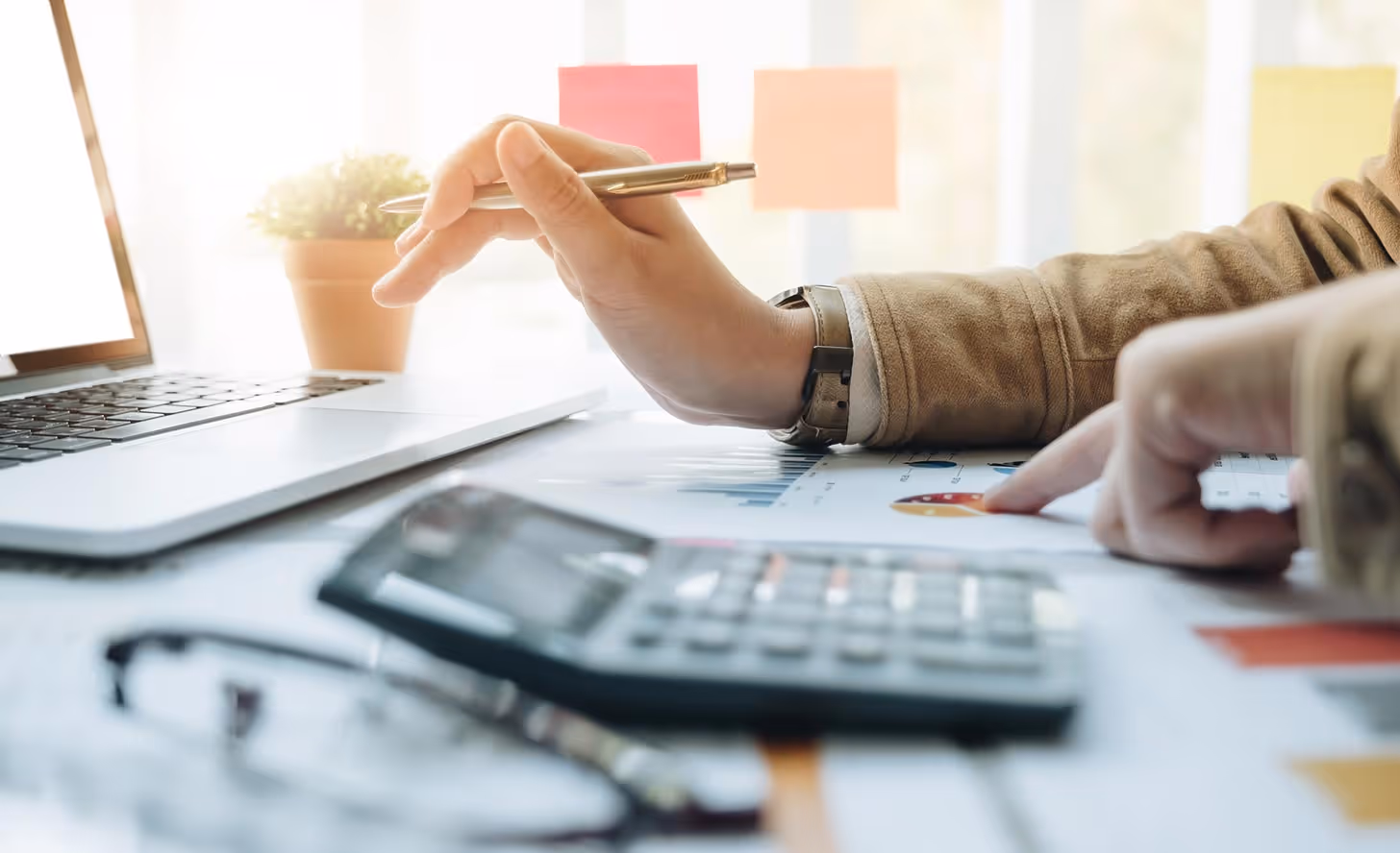 Image of a person working at a desk with a calculator