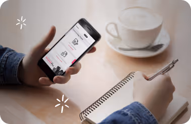 Image of crunch software on mobile held by someone writing in a notepad