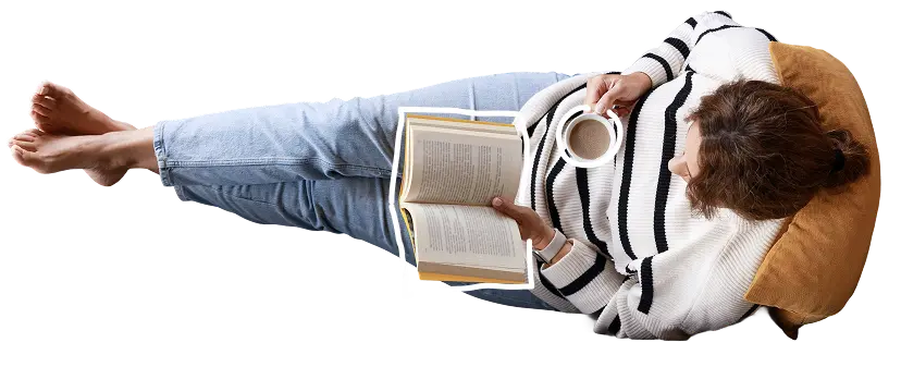 Person lying on a pillow reading a book while holding a cup of coffee. With text: "Put your feet up whilst we take care of your tax!"