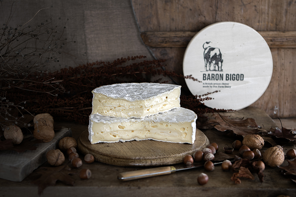 Baron Bigod cheese slices, on a wooden board, with the Fen Farm Dairy Baron Bigod box