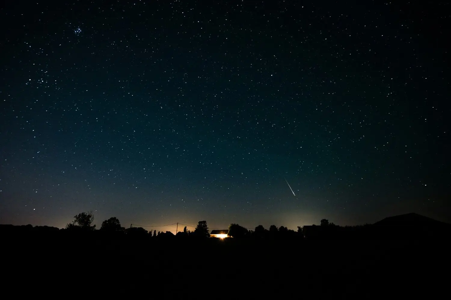A night sky over a dark horizon