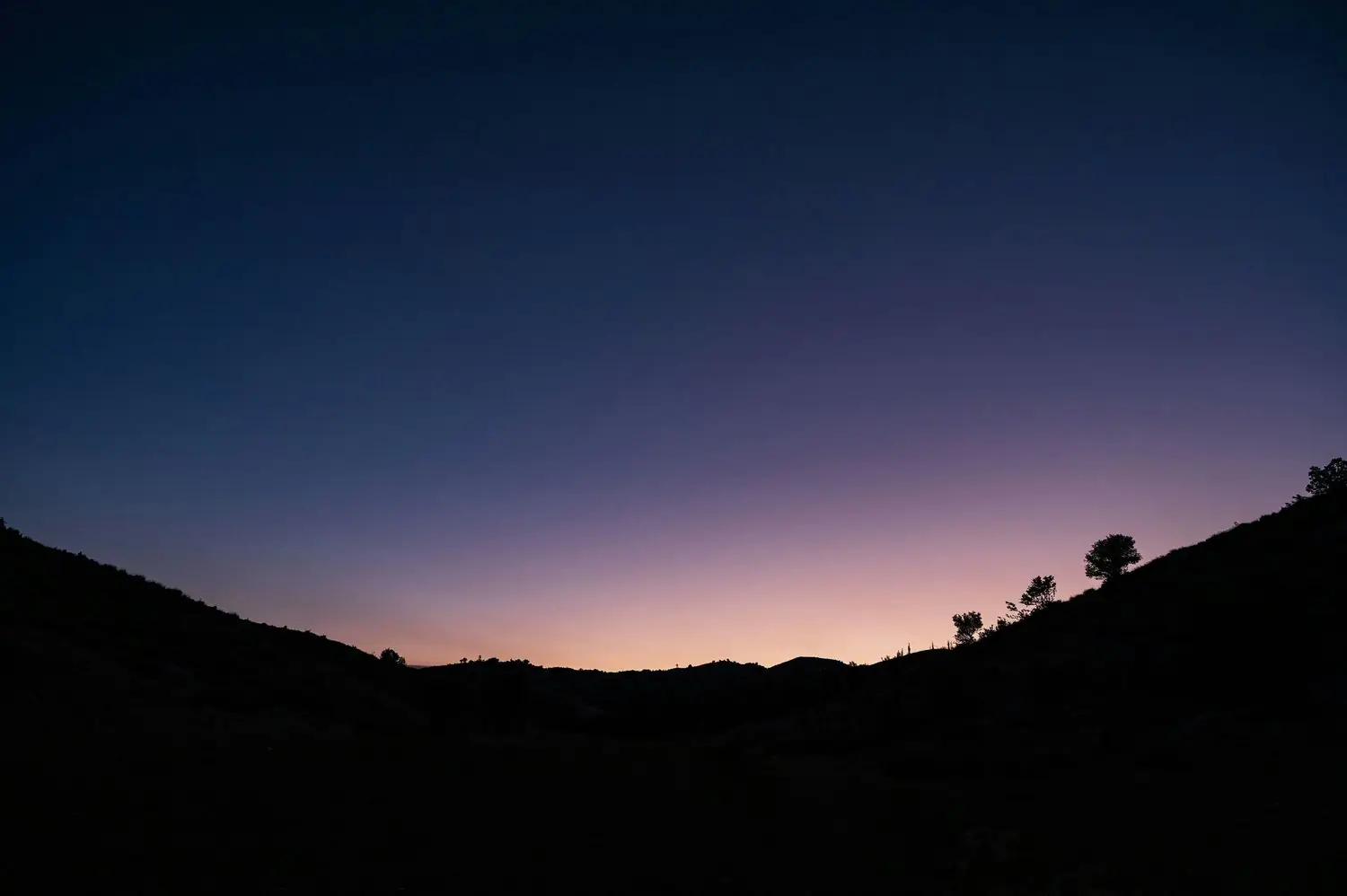 A silhouette of hills at dusk