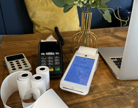 Card terminals, receipt rolls and a laptop on a salon desk