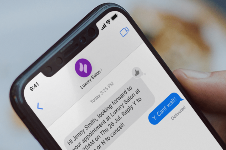Phone showing an automated appointment reminder text from a salon