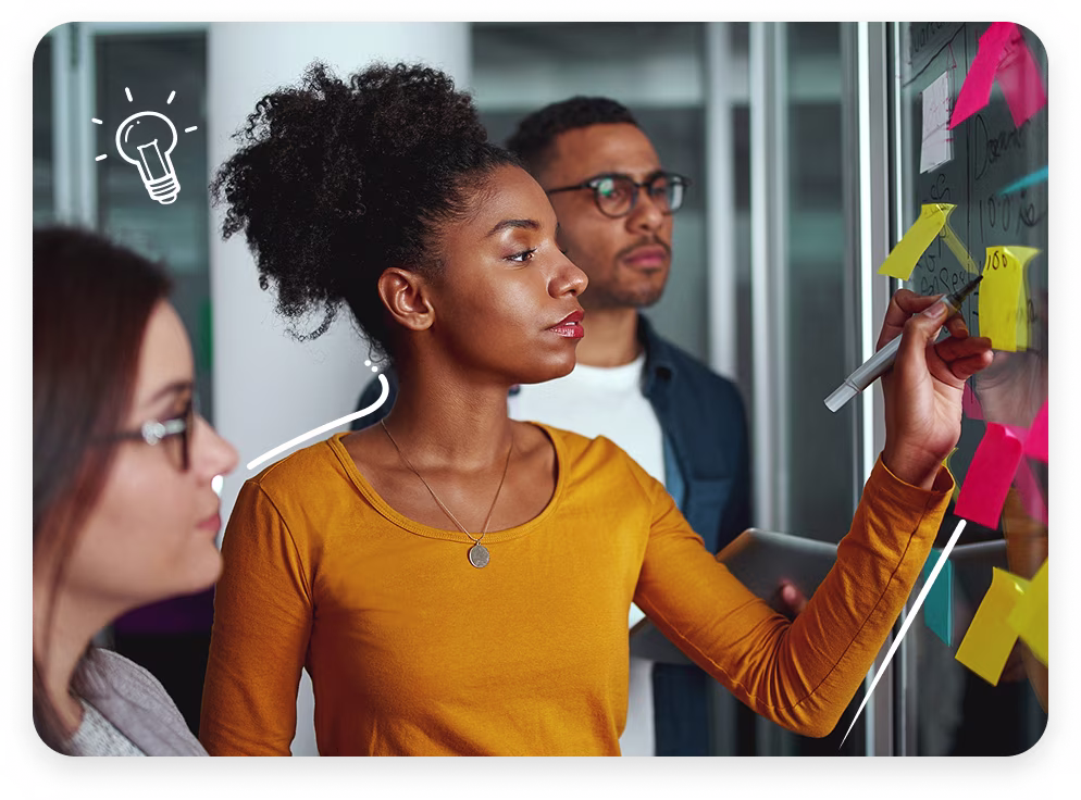 Image of a designer looking at post-it notes on a board.