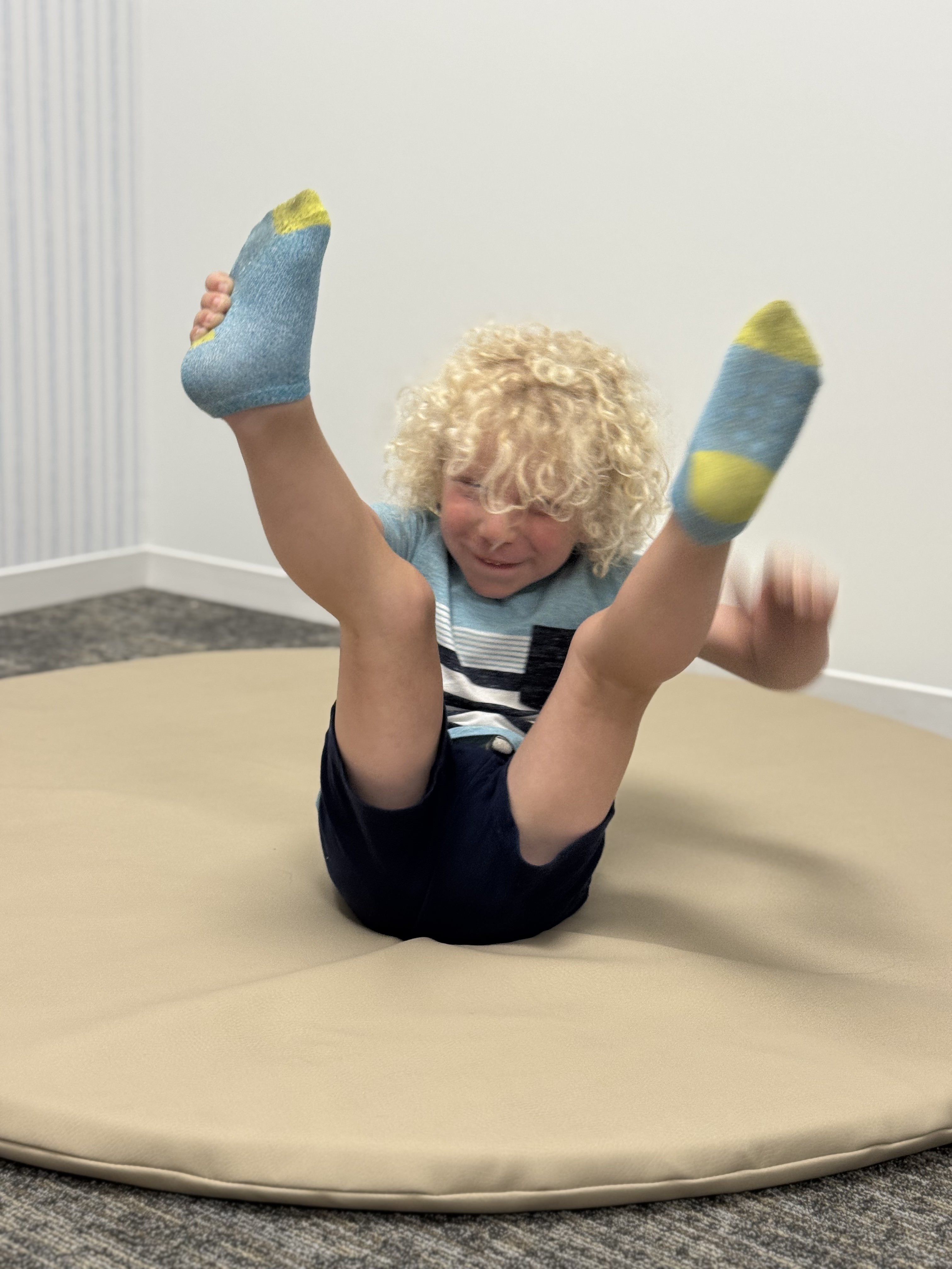 small child sliding down into a ball pit