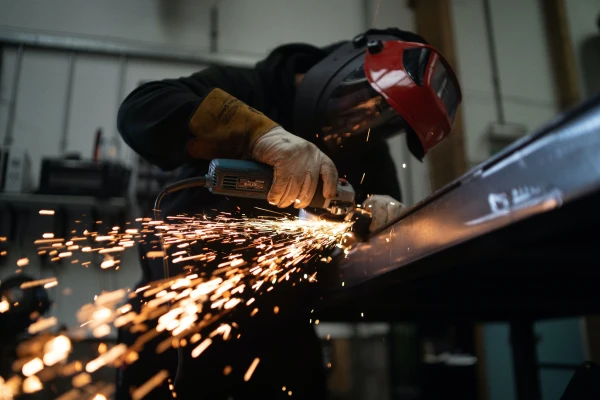 Manufacturer cutting steel from a frame