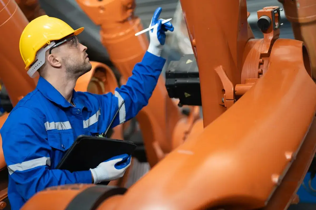 Man in manufacturing facility working on a machine.