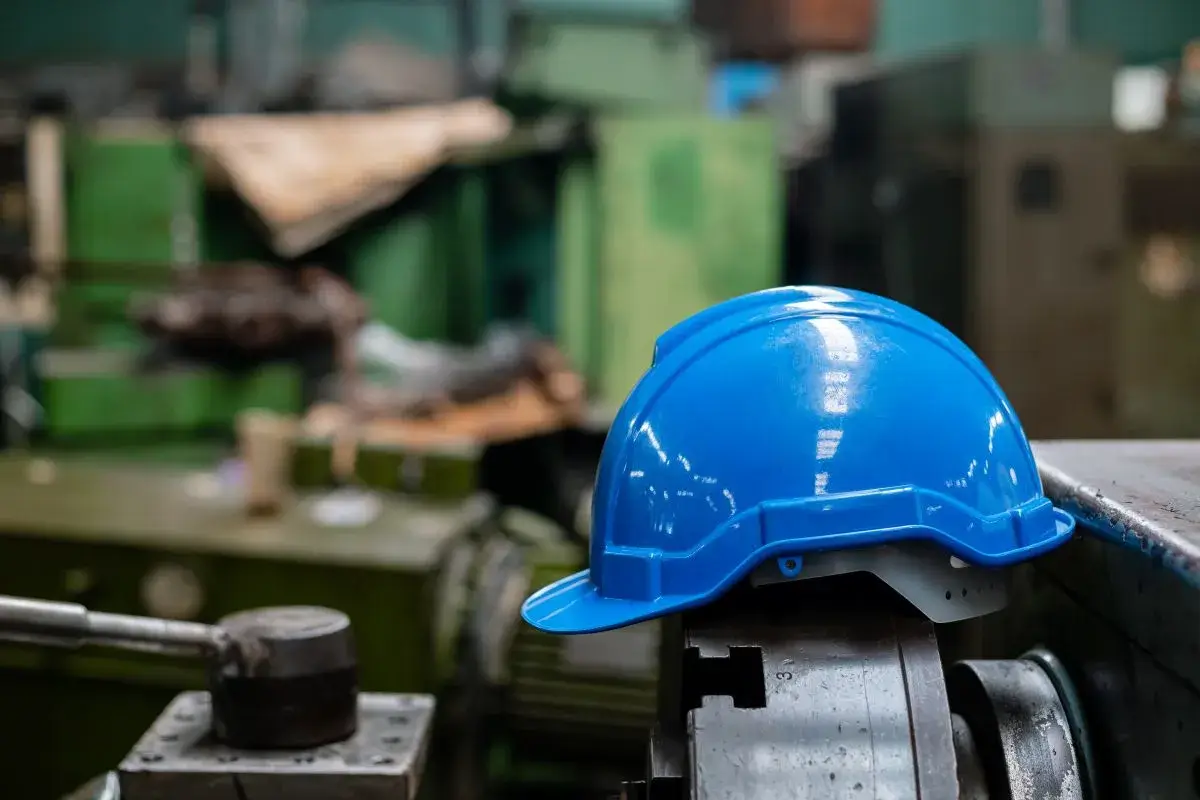Close-up shot of a blue construction hat inside a manufacturing facility.
