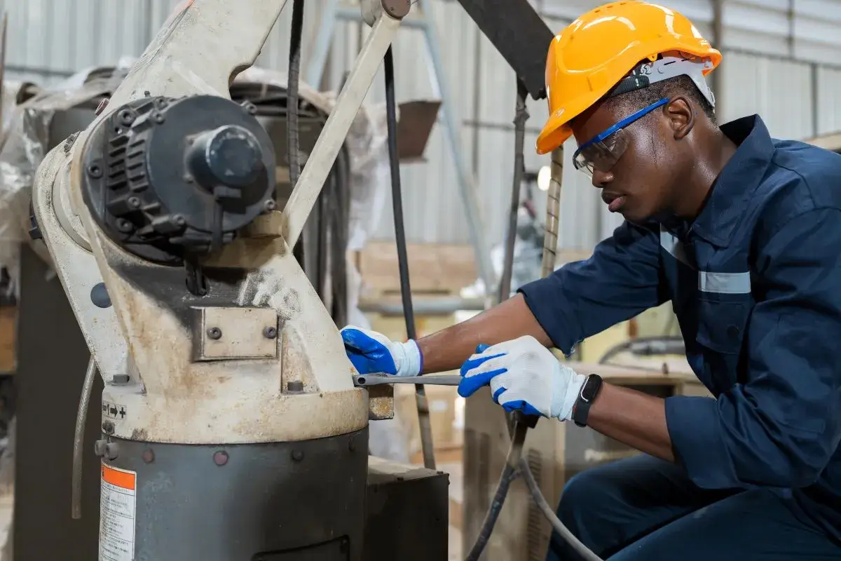 Man working on a machine in a manufacturing facility.