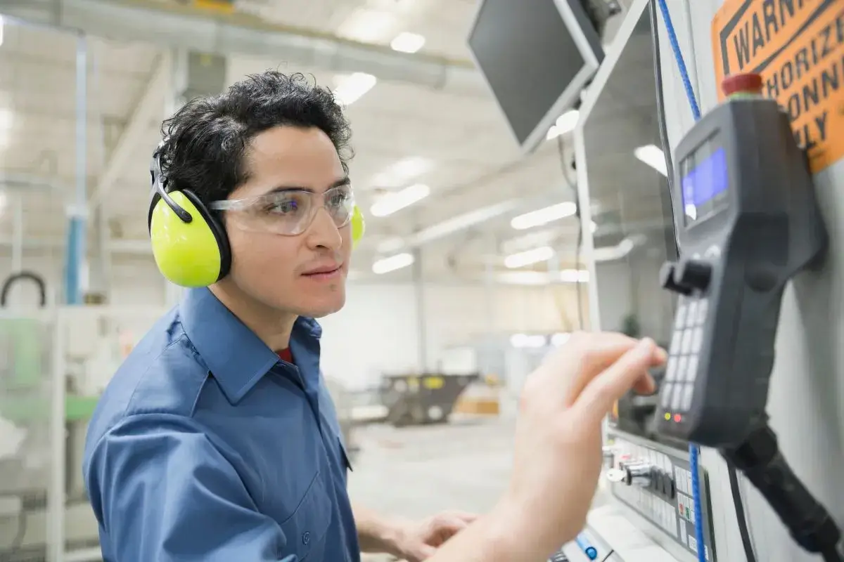 Man working on a machine in a manufacturing facility.