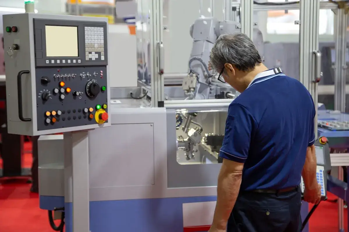 Man in manufacturing facility working on a machine.