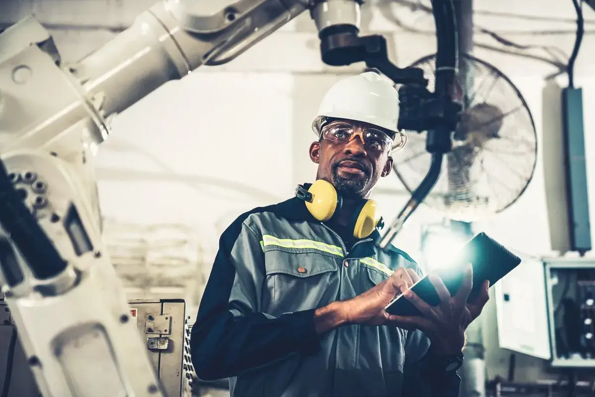 Man in manufacturing facility working with manufacturing equipment.