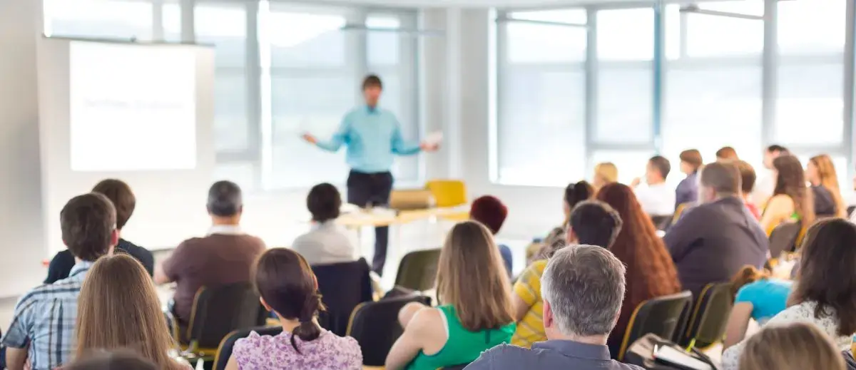 Group of people sitting in chairs watching a presentation.