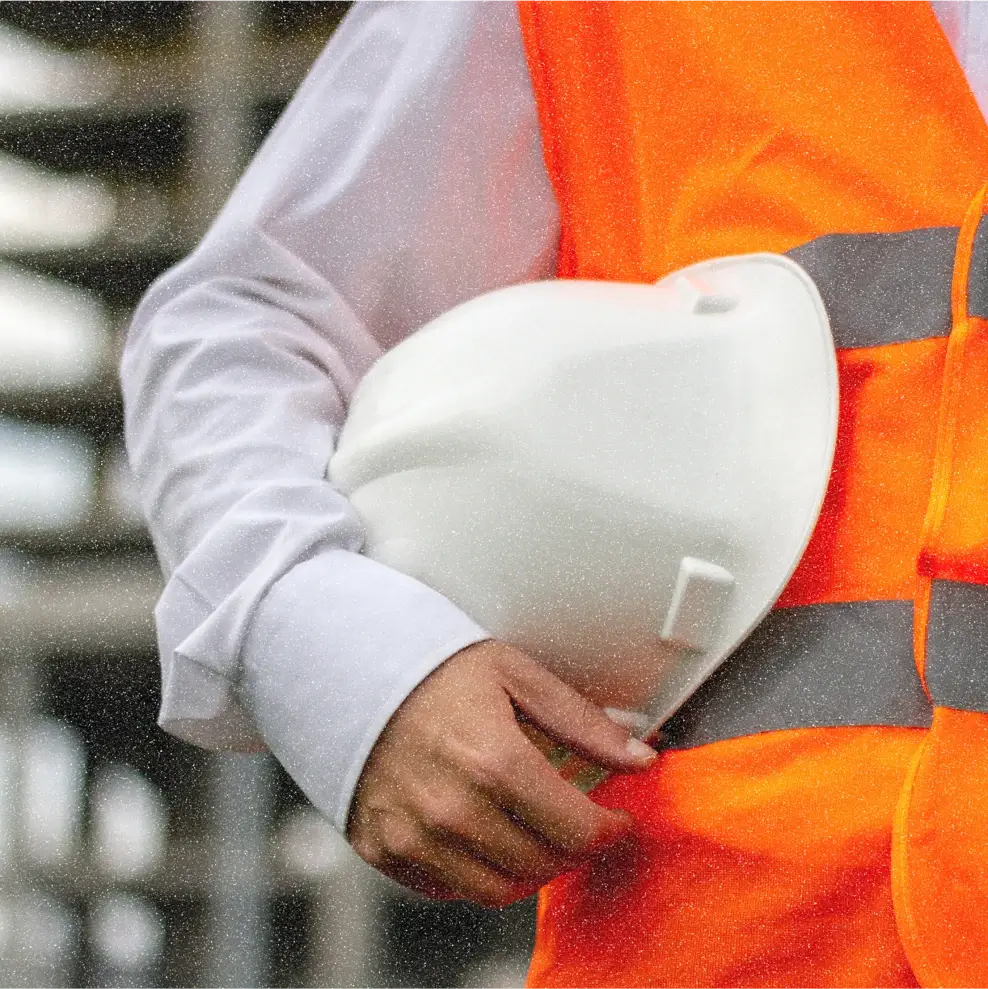 A man holding his hard hat outside the facility. 