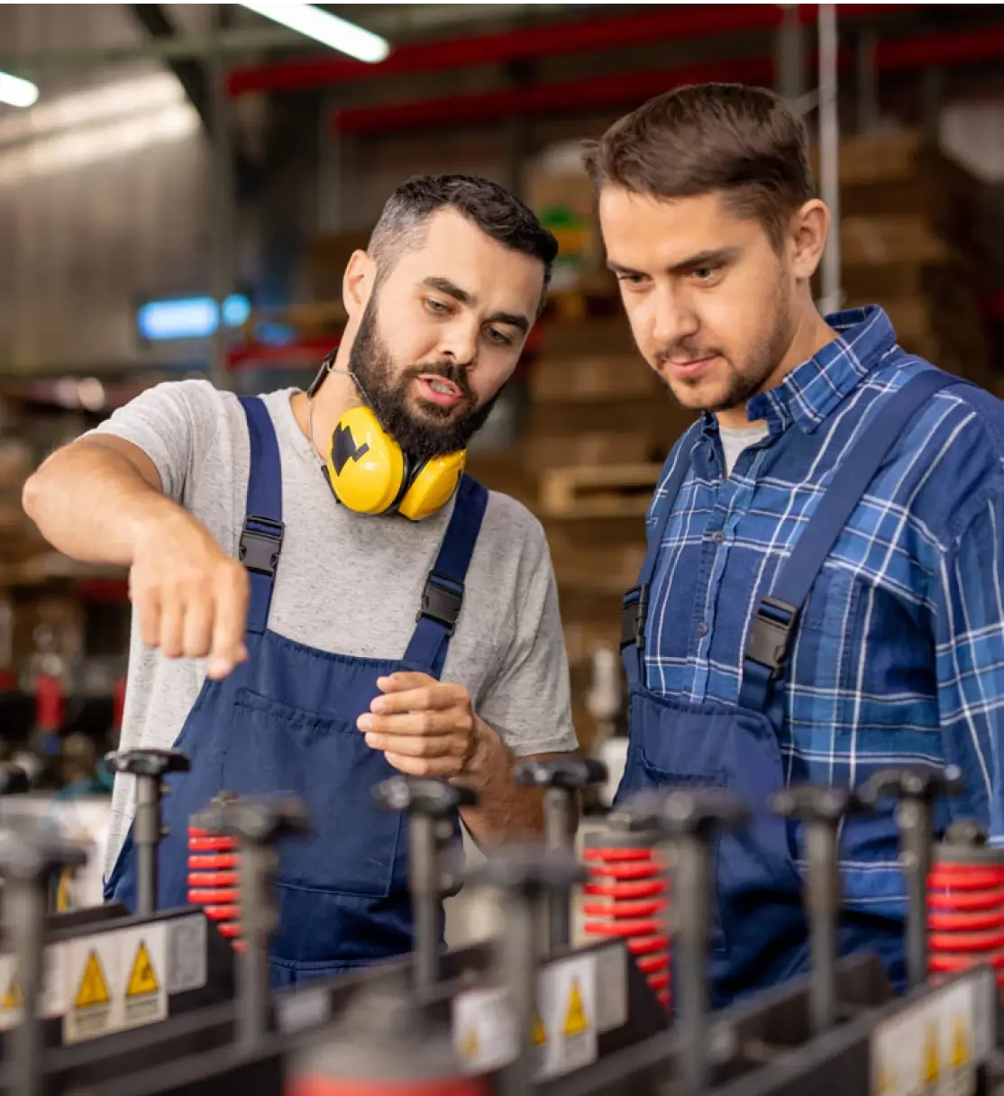 An experienced manager is cross-training an employee on an unfamiliar machine.