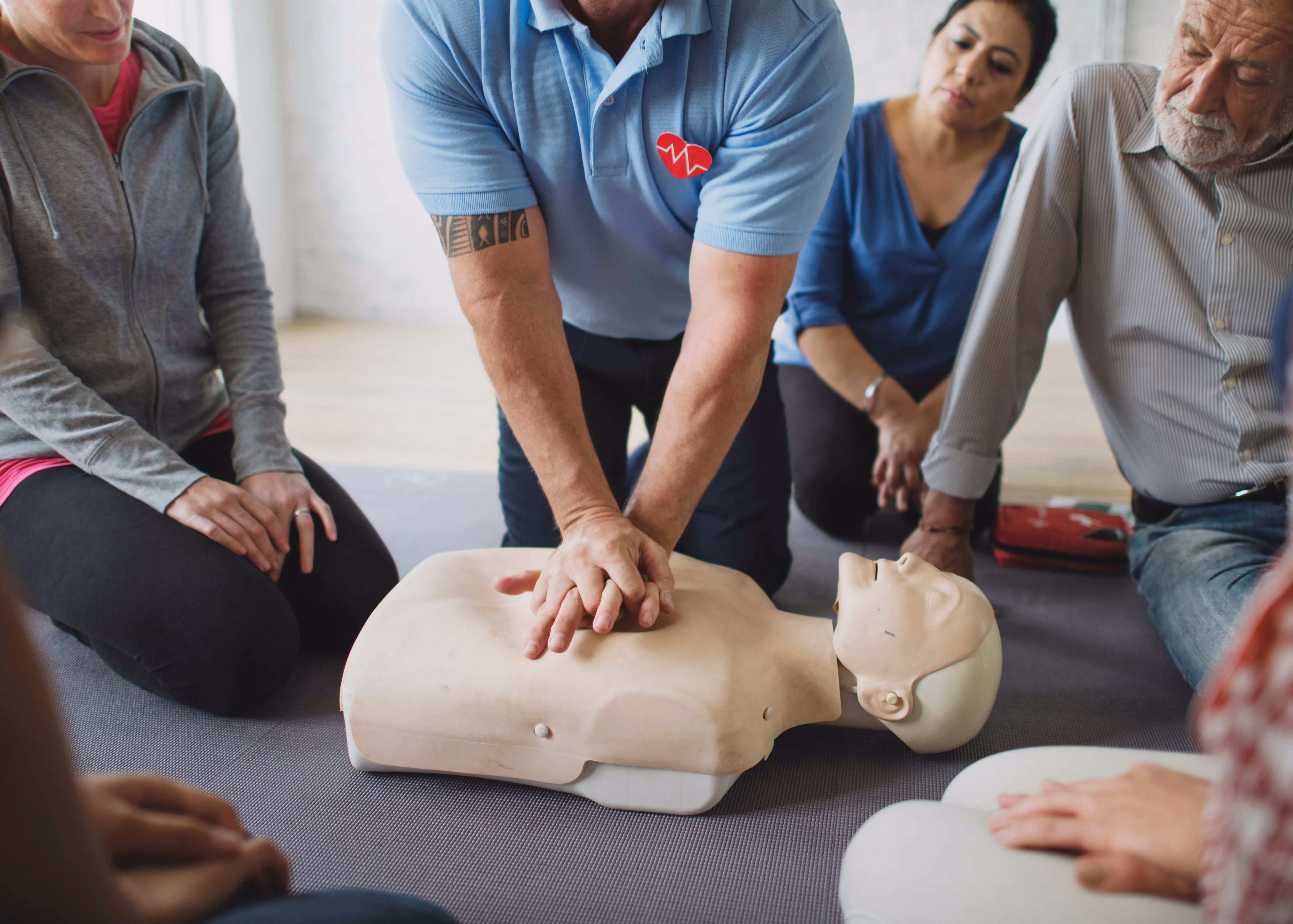 First aid trainer demonstrating CPR to a group