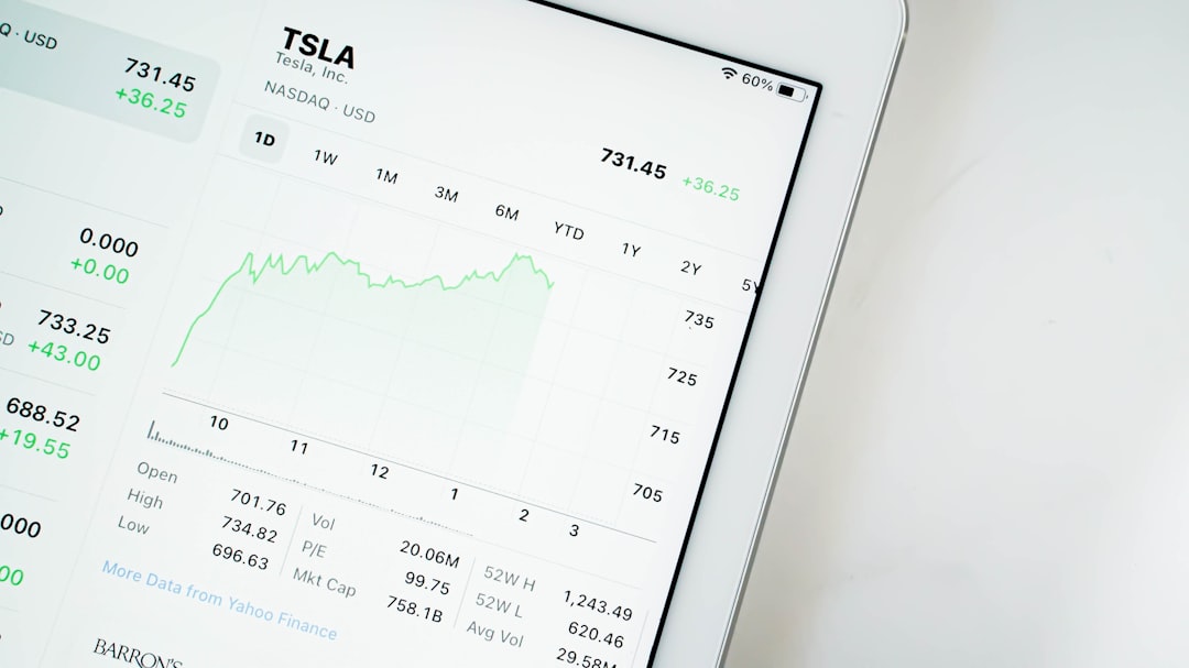 A modern branding agency workspace showing a laptop displaying accounting software dashboard with financial charts and project timelines.