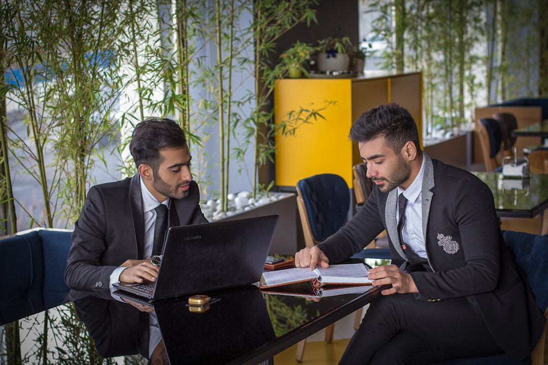 A modern AI agency workspace with multiple computer monitors displaying financial dashboards and profitability software analytics.