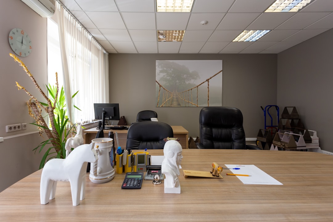 A modern branding agency workspace with multiple computer screens displaying financial dashboards, project management software, and profitability analytics.