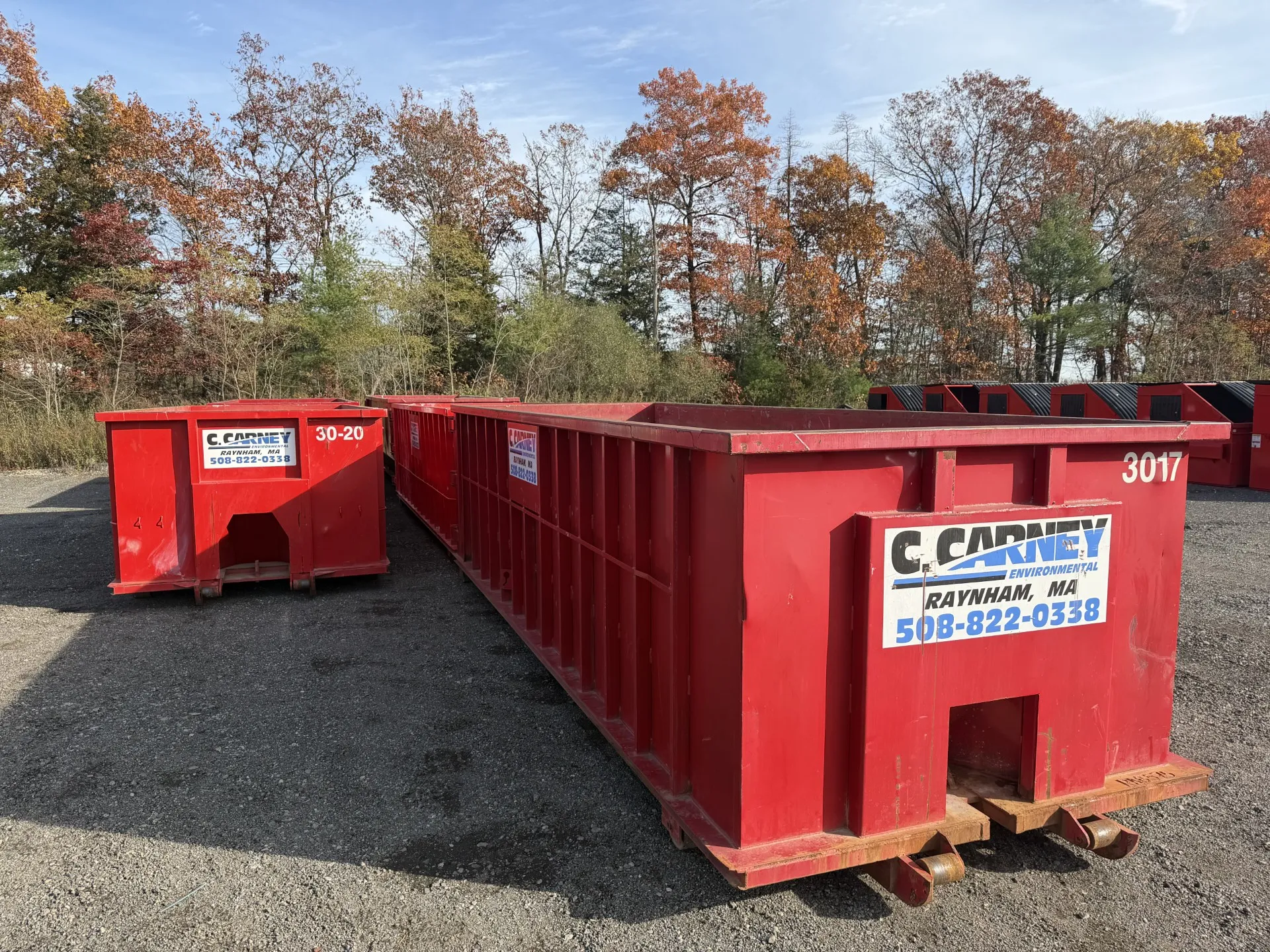30 yard red Carney Environmental roll-off dumpster in front of an autumn background