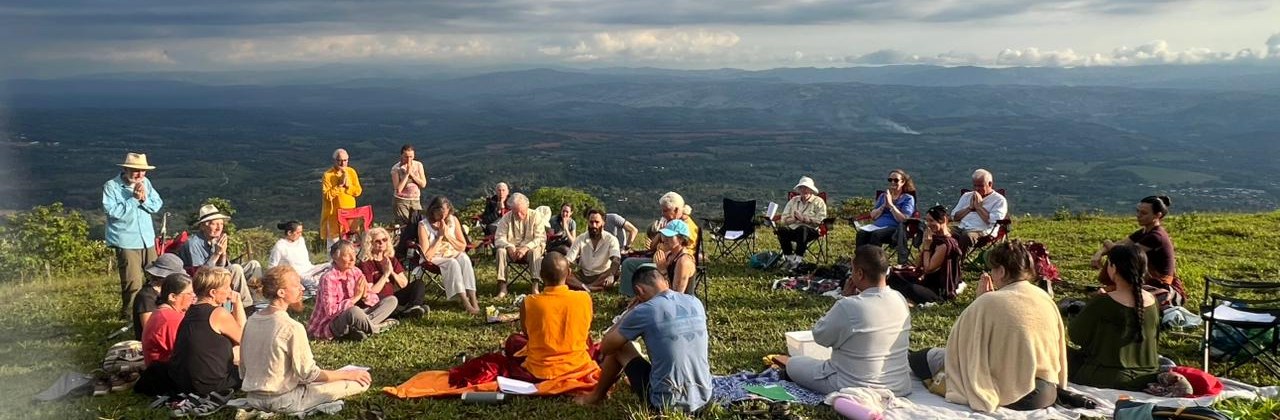 A group practicing in a circle with Lama Dorje on a hilltop above the valleys of Costa Rica