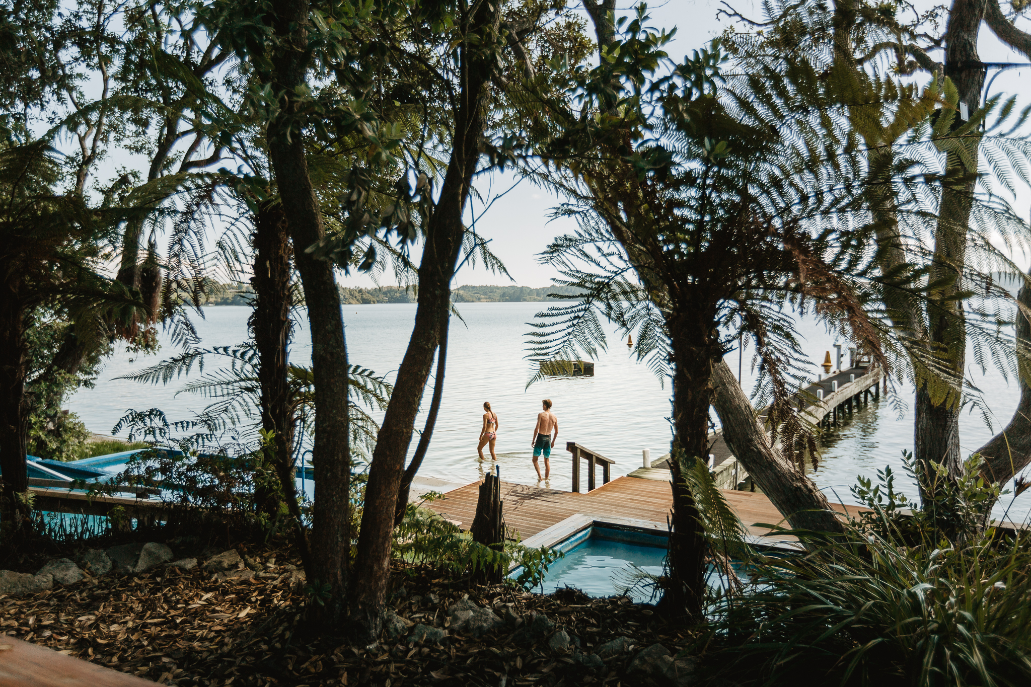 Guests enter the clear fresh water of Lake Rotoiti from the Manupirua hot pools area