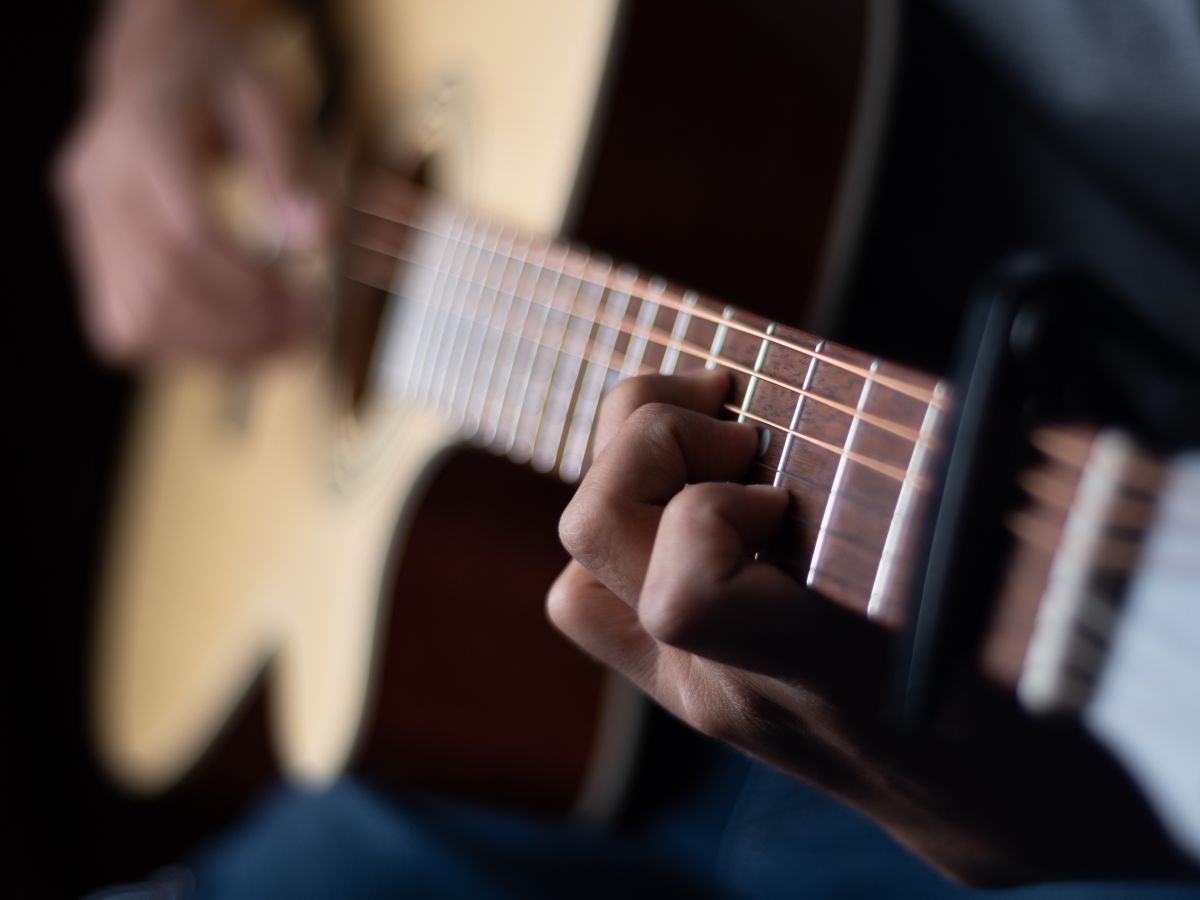 Someone holding a guitar and playing it