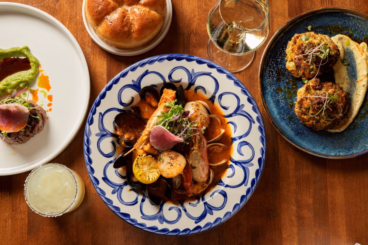 Various plates of seafood dishes on a wooden table