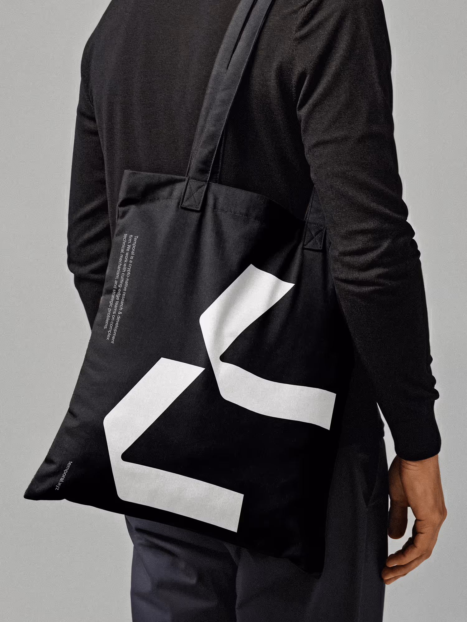 Man dressed in black wearing a Temporal totebag