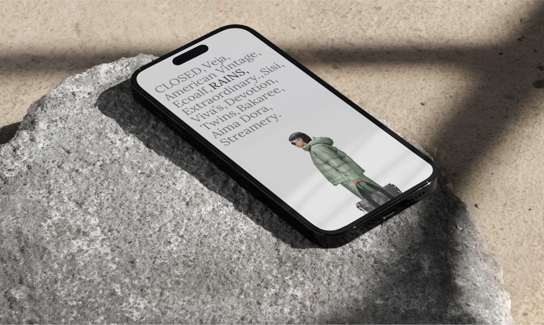 An iPhone laying on a rock and displaying a section from the website