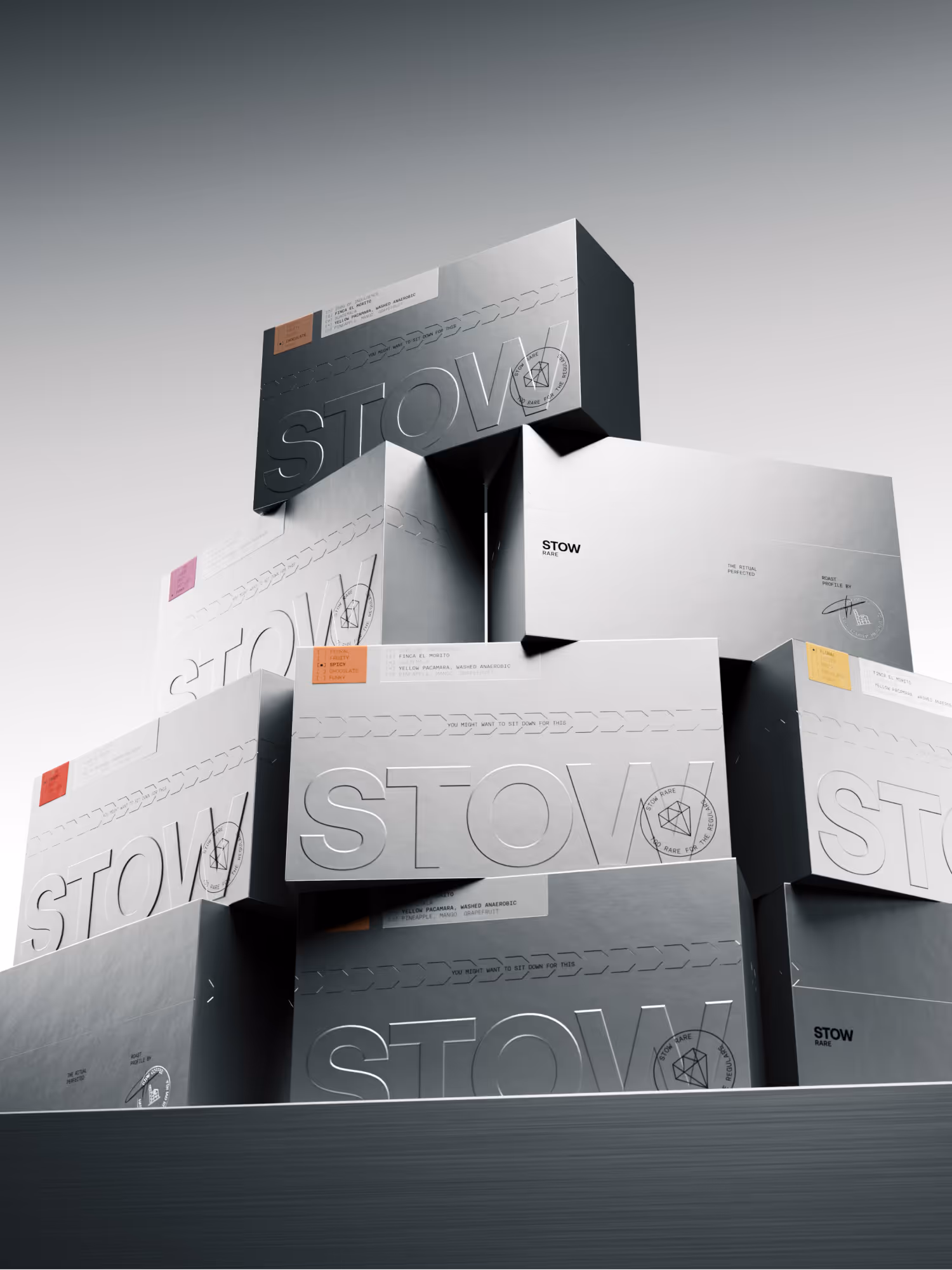 Stack of sleek metallic boxes with embossed 'STOW' branding and colorful flavor labels in a minimalist setting.