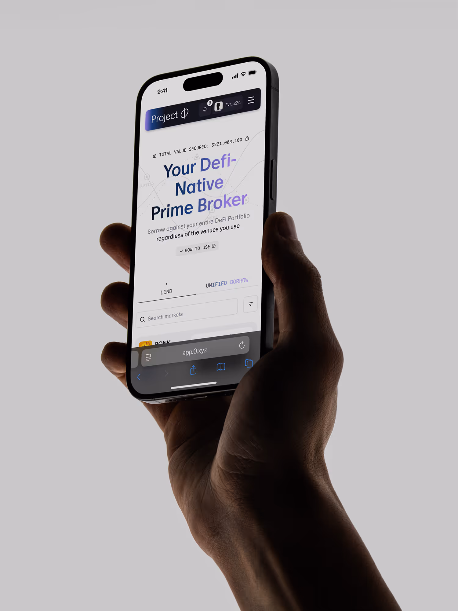 Hand holding a smartphone displaying Project φ DeFi lending platform with borrowing options.