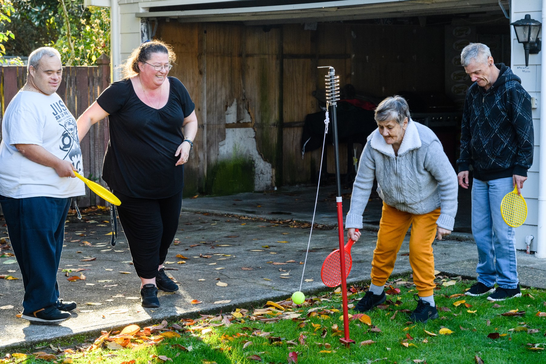 A support worker playing a game with the people she supports