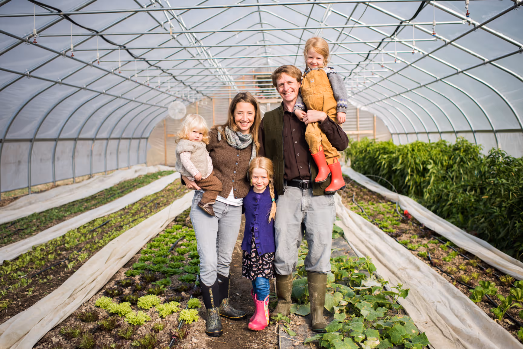 Family poses in a greenhouse