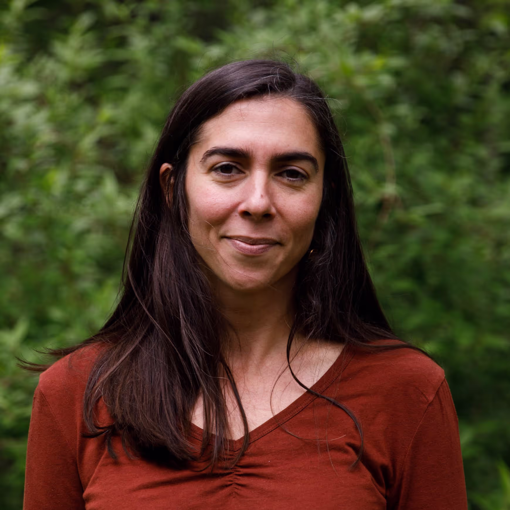 A woman in a red shirt posing for a picture