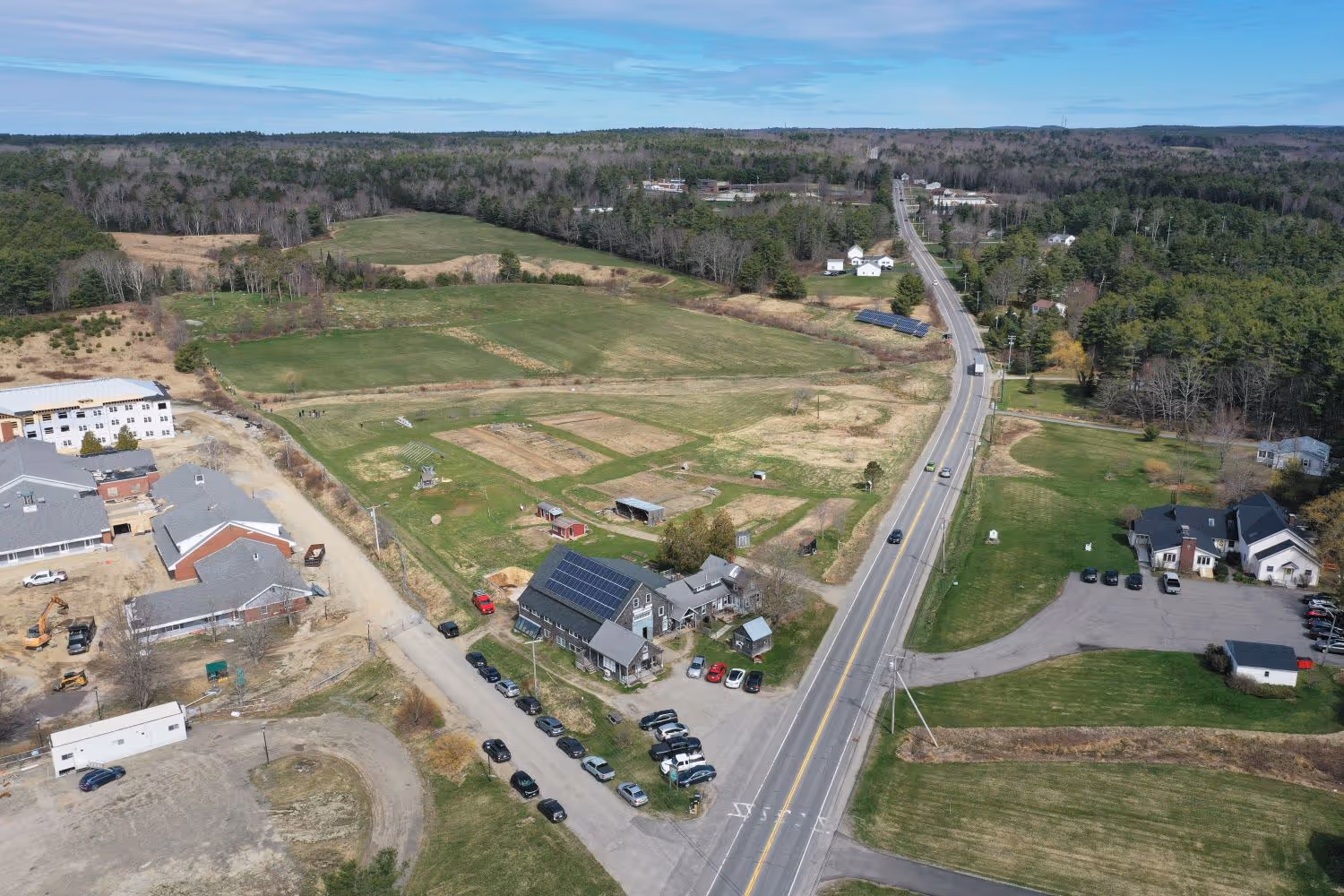 Aerial view of rural town with roads, fields, houses, and solar panels