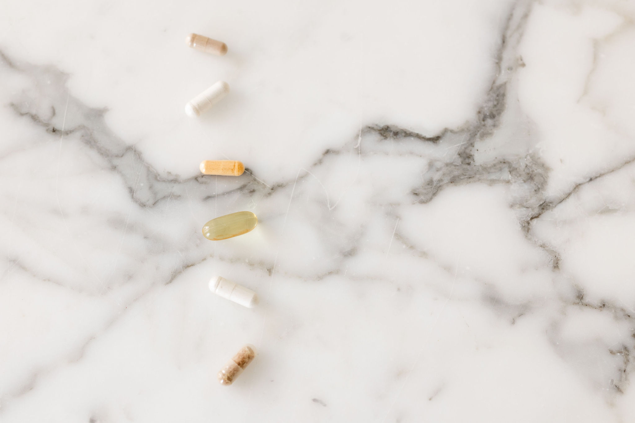 Dr. Margot ND blog on choosing a supplement. Photo includes 5 different supplements on a white marble counter — naturopathic care West End Toronto