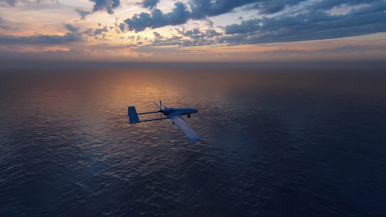 Unmanned aircraft flying over the ocean at sunset