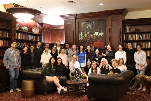 Large group of people smiling at the camera in a fancy meeting room