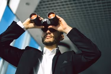 Man with binoculars checking on the competitors