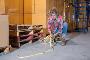 Woman picking trash from the warehouse