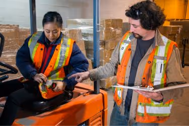 Person reminding someone to wear a safety belt while driving a forklift