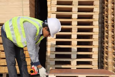 Worker measuring pallets