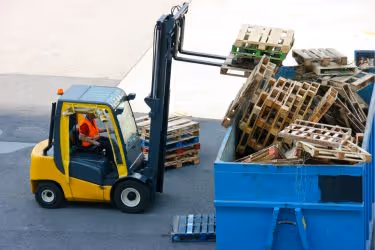 Forklift throwing away wooden pallets