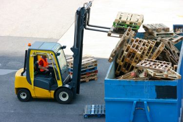 Forklift throwing away wooden pallets