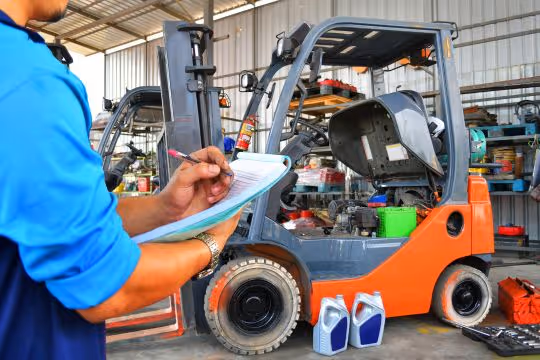 Preventative vs Fix-It Maintenance for Pallet Plants - Man giving maintenance to a forklift