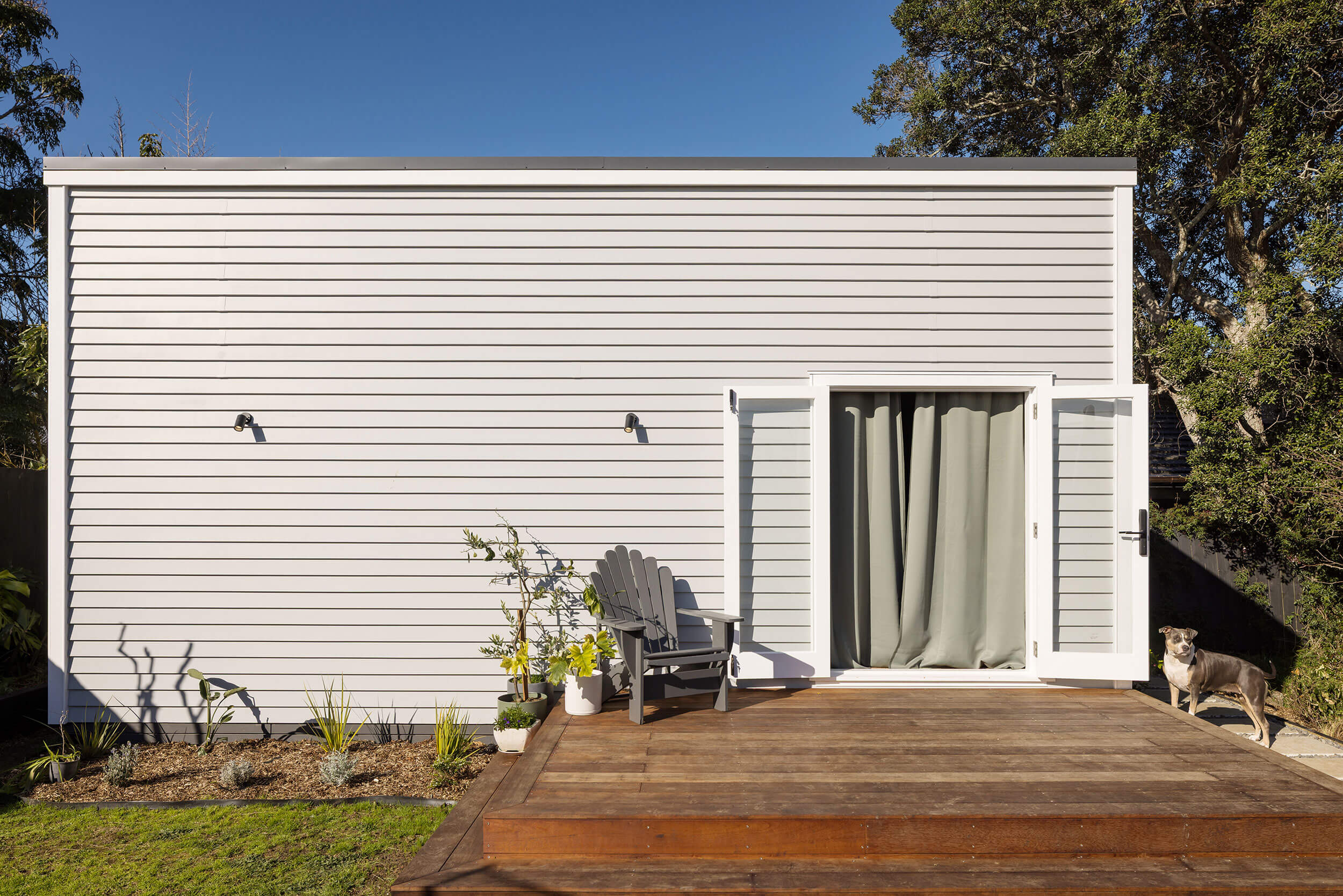 Weatherboard golf simulator and home office in Sandringham, with double doors open onto a deck